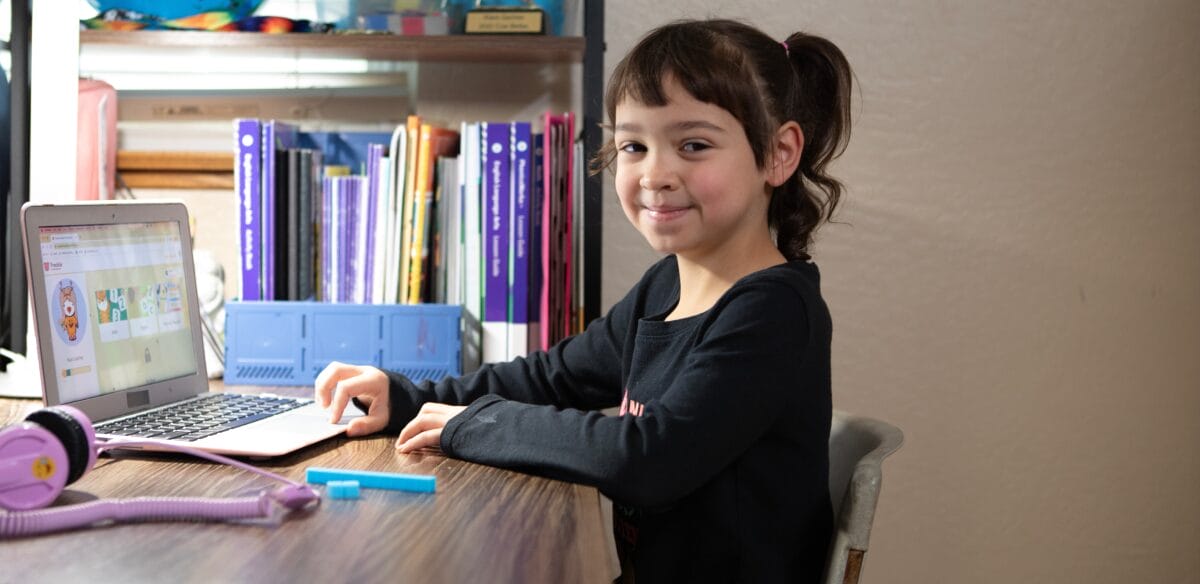 Elev de școală primară care participă la un curs online acasă